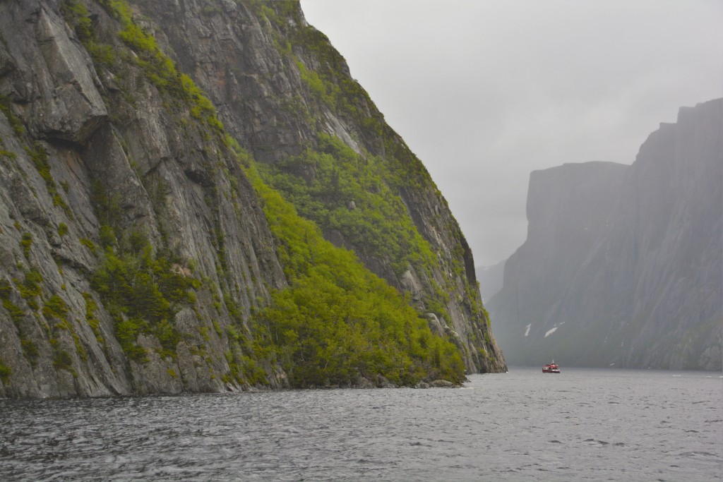 Our sister boat is dwarfed by the size of the rock faces leading down to the water