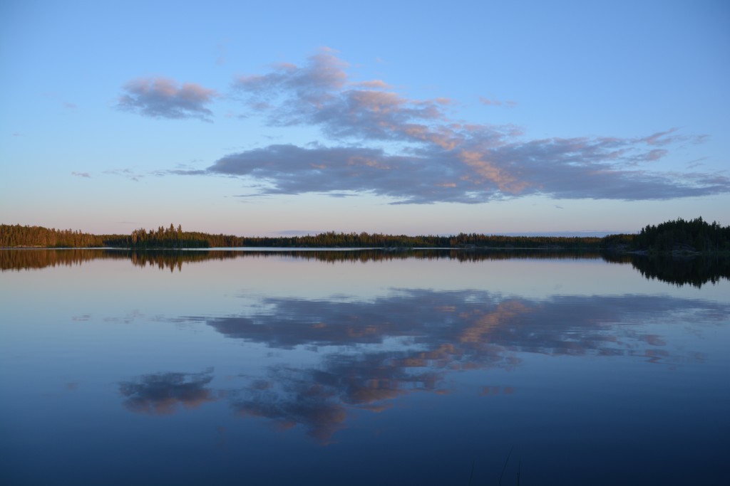 The perfect reflection of shoreline and clouds across the lake